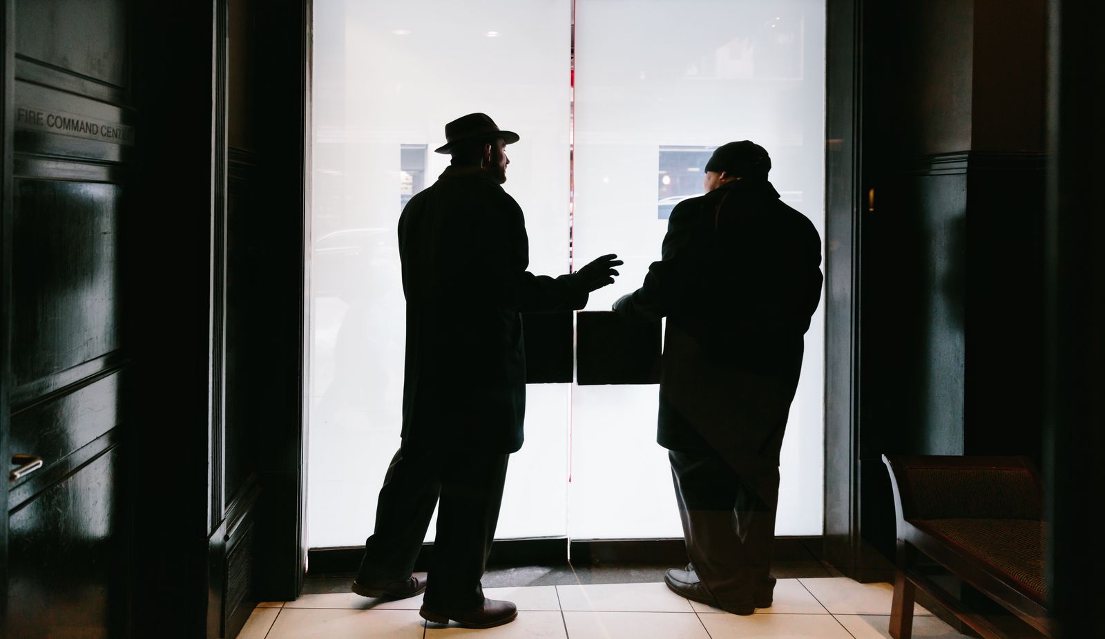 two doormen conversing just inside the fifteen beacon hotel.