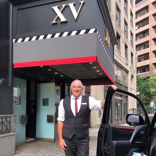 male hotel employee standing outside of the XV Beacon Hotel